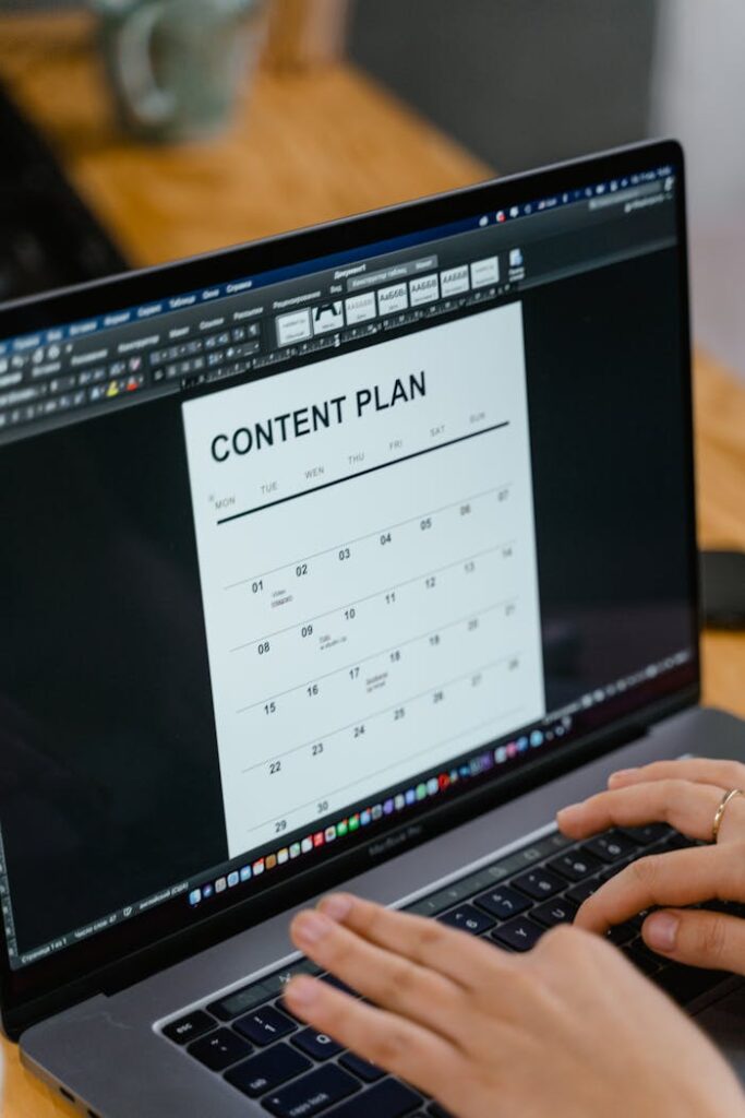 Mastering the First Impression: Your intriguing post title goes here Close-up of hands typing on a laptop displaying a content plan document, ideal for business or marketing content.